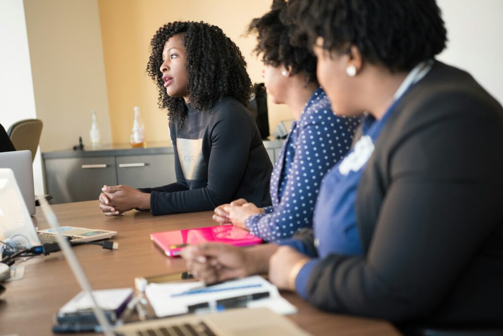 A woman speaking to a group of people who are using laptops