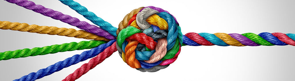 A teal, purple, yellow, green, blue, and red rope that transitions from coming together to form a tangled ball, into one interlocking rope