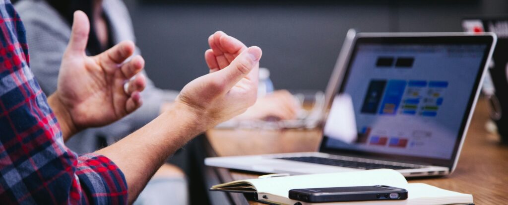 A person using a computer and using hand gestures to communicate