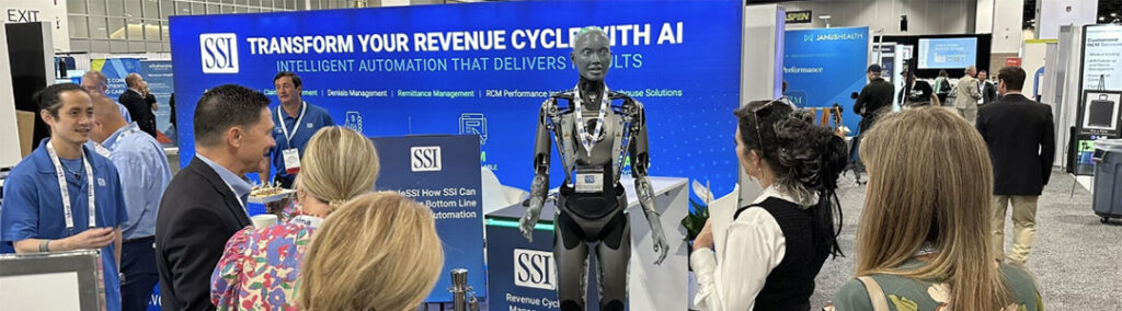 A robotic human in front of an SSI booth at HFMA with a group of people