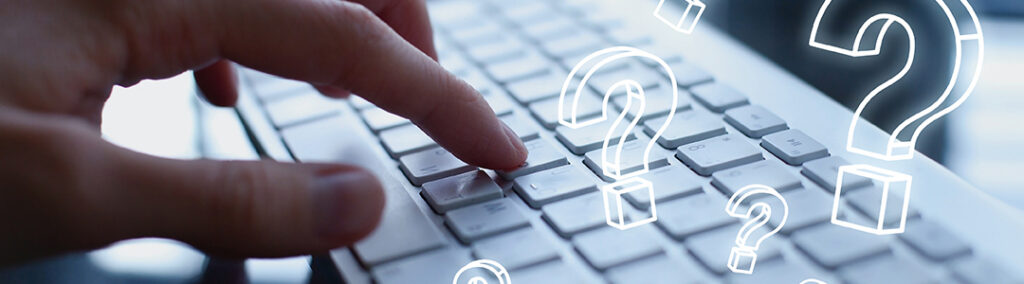 A hand typing on a keyboard with question mark graphics.