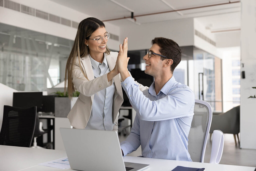 woman and man smiling while high-fiving