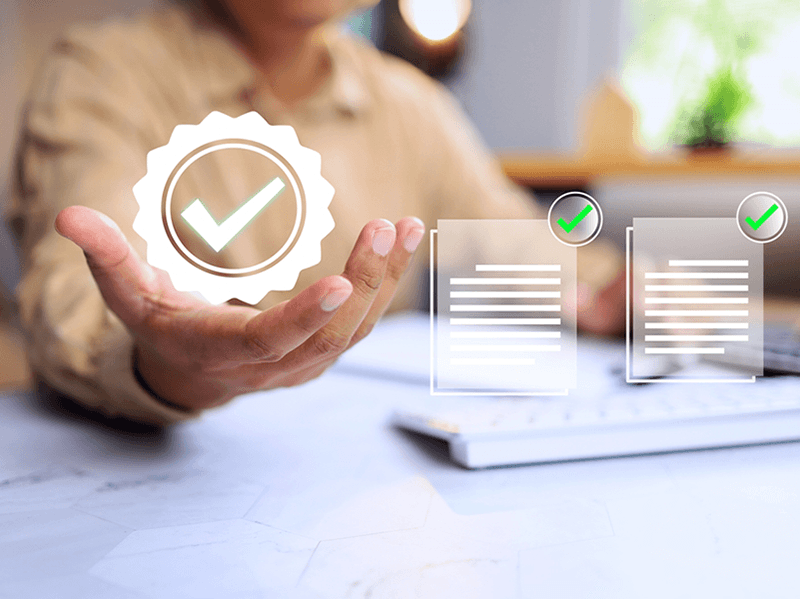 hand holding checkmark surrounded by certification seal
